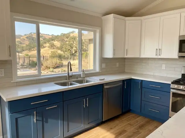 New kitchen cabinets with white shaker uppers and deep blue lower cabinets