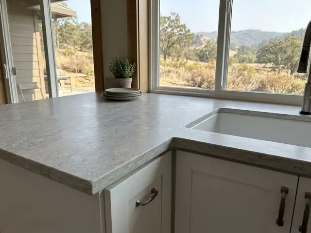 New light grey stone-look countertop with an undermount sink on white cabinets